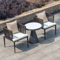 Table de salle à manger d'extérieur moderne avec cadre en aluminium et chaises en rotin, livrée avec coussins pour jardin ou restaurant