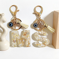 Porte-clés Alphabet en résine effet grain de coquille crème, avec pendentif œil porte-bonheur en strass et pompon en daim blanc cassé, cadeau personnalisé