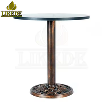 Table ronde en fonte avec finition cuivre vintage, base sur pied robuste avec plateau en mélamine pour café, bar, restaurant