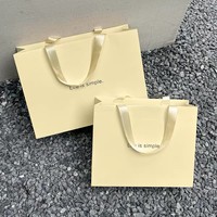 Sac cadeau en papier jaune clair, sac de transport en papier d'art, sac de shopping personnalisé avec logo pour l'emballage de vêtements et de produits de beauté