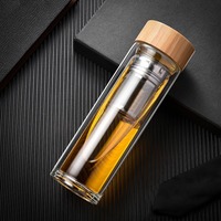 Fabricant de bouteilles en verre à double paroi avec logo personnalisé, vendant des bouteilles d'eau avec infuseur à thé et fruits, avec couvercle en bambou