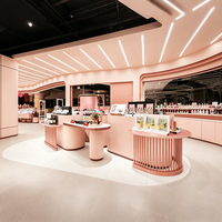 Ensemble de mobilier pour boutique de cosmétiques roses : table de vente incurvée avec grille intégrée et socle circulaire