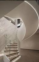 Escalier moderne en métal courbé avec toboggan et éclairage mural LED, garde-corps en verre, pour usage intérieur en villa