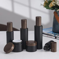 Ensemble d'emballages cosmétiques en verre noir mat en gros avec couvercle en bois, flacon pompe, pot à crème, flacon compte-gouttes pour sérum pour les soins de la peau