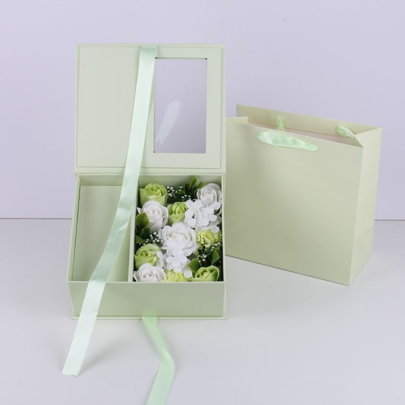 Boîte d'emballage verte avec sac à main et fleur