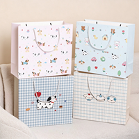 Sac cadeau en papier écologique durable imprimé avec un dessin de chiot mignon, avec poignée torsadée, pour fête d'anniversaire d'enfants