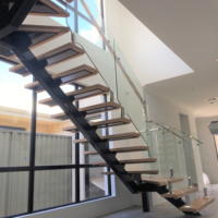 Moderne L-förmige Einholm-Treppe aus Metall und Holz mit Edelstahl-Gerüst und Glasgeländer für Luxushotels und Apartments