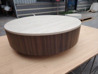 Table basse ronde en travertin clair avec placage en bois foncé, style minimaliste pour salon