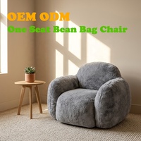 Fauteuil pouf monoplace en forme de galet avec dossier et accoudoirs de soutien, revêtement en fausse fourrure, design moderne, garnissage en linge déchiqueté pour salon