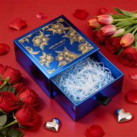 Boîte à tiroirs bleue métallisée personnalisée avec fleurs dorées en relief pour un emballage de marque élégant
