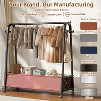 Porte-vêtements triangulaire commercial en acier de 125 cm sur roulettes avec bac de rangement inférieur en non-tissé – Produit par un fabricant en gros