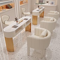 Table de manucure double poste de luxe avec plateau blanc, base en lattes de bois, 2 chaises crème dorées et étagères de rangement pour salon de manucure