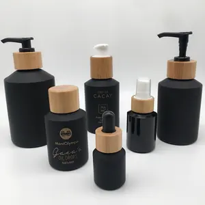 Set di bottiglie e barattoli cosmetici confezione bottiglia e vaso di vetro a spalla inclinata nera opaca con coperchio in bambù la fabbrica fornisce direttamente