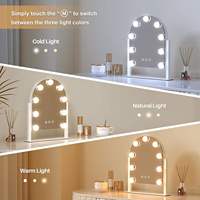 Miroir de maquillage sur pied avec écran tactile personnalisable et design arqué, doté de 9 ampoules LED réglables.