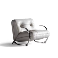 Fauteuil lounge luxueux rembourré avec structure en métal finition laiton courbé et accents en cuir capitonné pour salon, hôtel, villa