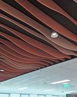 Traitement acoustique de plafond en feutre PET absorbant le son, avec déflecteurs superposés à lignes ondulées et fluides pour un rythme et un mouvement sonores