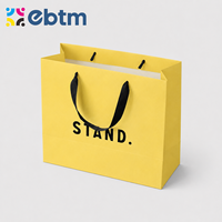 Sacs cadeaux en papier jaune mat personnalisés en gros avec poignées en ruban noir pour sacs cadeaux cosmétiques