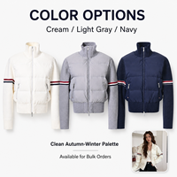 Blouson matelassé pour femme en techniques mixtes, 90% duvet de canard blanc, manches en tricot matelassées, col montant, coupe courte, marque privée