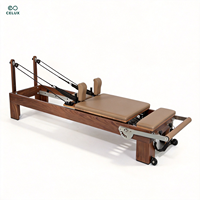 Machine de Pilates Reformer professionnelle haut de gamme en cuir microfibre et bois de noyer foncé avec ressorts allemands pour le renforcement musculaire