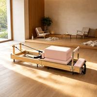 Machine de Pilates Reformer en bois avec coussin rose pour entraînement du tronc, étirements et entraînement complet du corps à domicile ou en studio