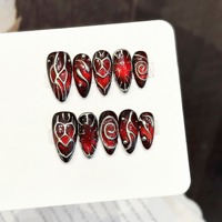 Nail art tridimensionnel à motifs sombres rouges et bruns avec texture en forme de cœur, accessoire tendance et artisanal.