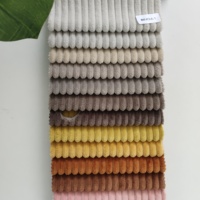 Corduroy 100% polyester à larges côtes avec des côtes épaisses et arrondies en peluche douce créant une texture douillette, semblable à du velours
