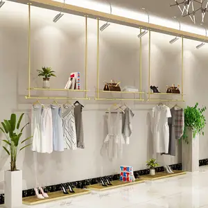 Prateleira de pendurar para loja de roupas, design interior de loja de roupas personalizado com teto de ouro e metal