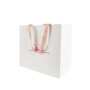 Custom Logo Stamping White Gift Paper Bag with Pink Ribbon Handles for Cosmetics Features Bow Knot Design