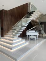 Escalier suspendu moderne en spirale pour salon, en bois massif, avec verre anti-explosion et main courante sans cadre
