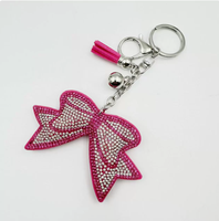 Koningsblauwe modieuze sleutelhanger met zwarte achtergrond, strikvorm, volledig bezet met strass steentjes en kwastjes, best verkochte charme hangende ornament