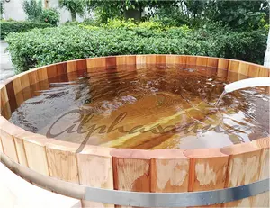 裏庭の丸い杉の木製の温水浴槽