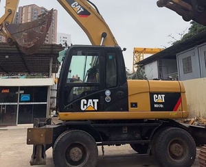 Excavatrice sur pneus CAT M317D2 <span class=keywords><strong>d</strong></span>'occasion à faible nombre <span class=keywords><strong>d</strong></span>'heures de fonctionnement avec dozer frontal, stabilisateurs arrière et ligne de brise-roche préinstallée pour l'asphalte - Product Image 1