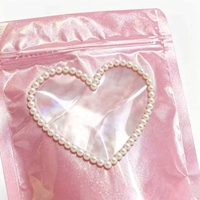 Pochette d'emballage refermable à fermeture éclair holographique rose brillant avec logo personnalisé, bordure perlée et fenêtre transparente en forme de cœur pour bijoux