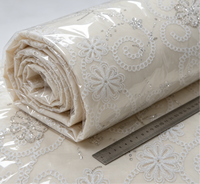 Tissu tissé de poids moyen avec broderie florale ajourée blanche et accents de perles tubulaires en sequins argentés pour abayas et hijabs de mariage