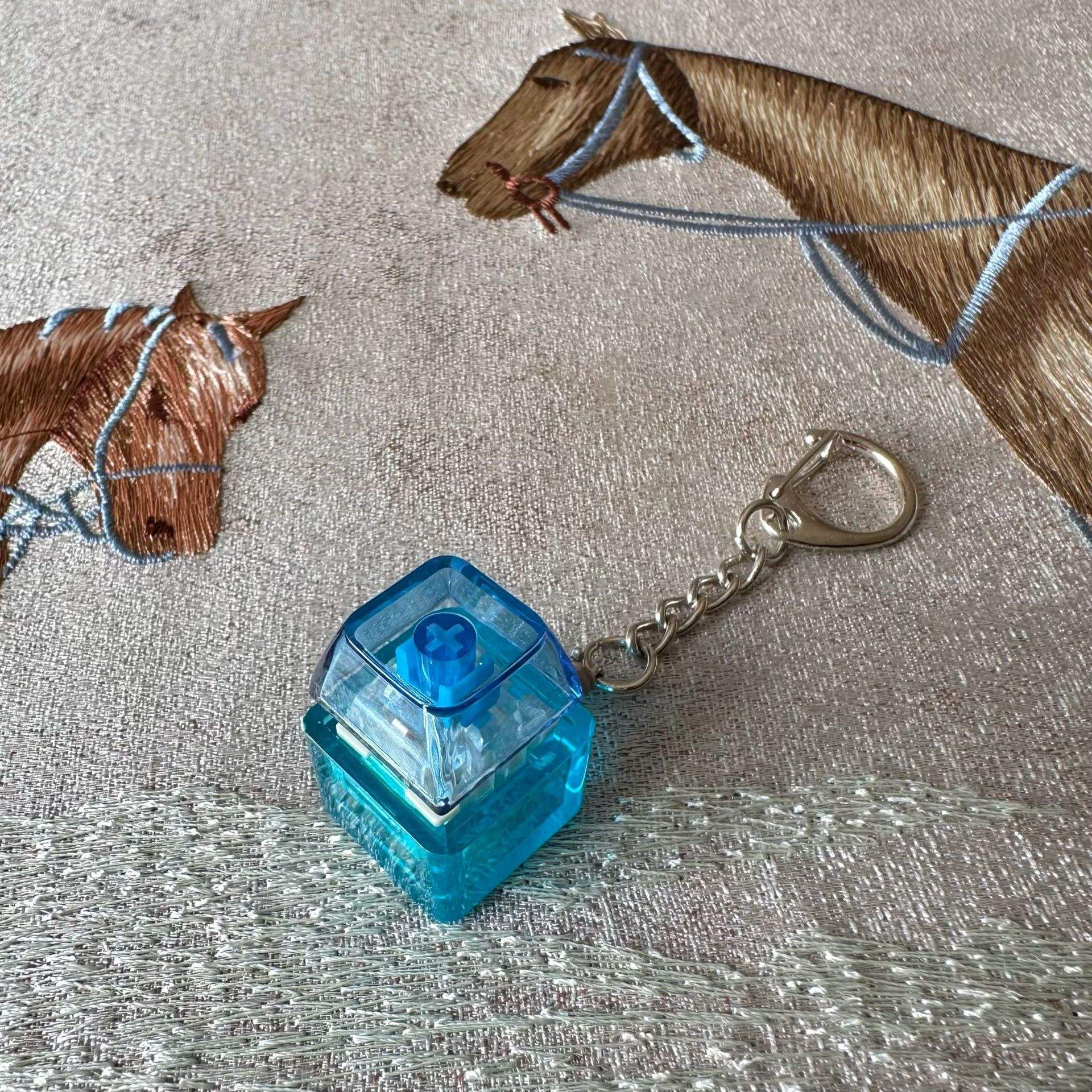 Clé unique n°2, boîtier bleu, capuchon transparent bleu, petite chaîne en D.