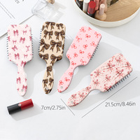 Brosse à cheveux démêlante portable style Coquette avec motif nœud léopard et coussin d'air, peigne de massage à palettes pour femmes
