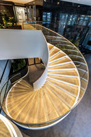 Escalier courbé empilable moderne avec garde-corps en verre et balustrade métallique, écologique, pour usage intérieur, durable, idéal pour hôtels et villas