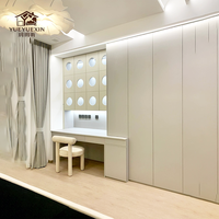 Armoire blanche sur mesure avec panneau ajouré à découpe circulaire et unité de coiffeuse intégrée pour projets de suites de chambre modernes
