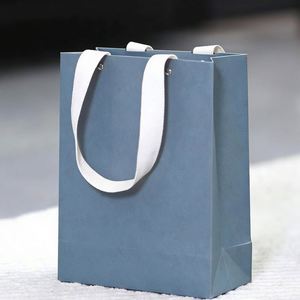Sac en papier bleu pliable pour le commerce de détail, avec poignée en coton recyclé et design perforé à rivets, personnalisable - Product Image 1