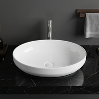 Lavabo ovale moderne en céramique avec robinet à levier, fixation sans perçage, finition lisse pour salle de bain d'hôtel