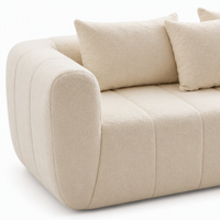 Canapé 3 places en tissu bouclé crème, capitonné, à profil bas et accoudoirs arrondis, pour maison rustique avec poutres en bois