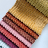 Corduroy 100% polyester à larges côtes avec des côtes épaisses et arrondies en peluche douce créant une texture douillette, semblable à du velours