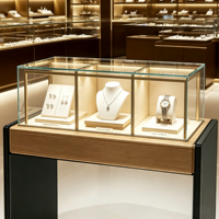 Vitrine à bijoux moderne et élégante avec dessus en bois clair, panneau latéral foncé, armoire en verre transparent avec éclairage LED chaud intégré pour la vente au détail de bijoux