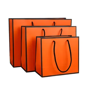 Bolsa de papel de compras personalizada de marca de lujo, con logotipo, impresión prémium en naranja y negro, embalaje de papel, bolsa de compras de regalo
