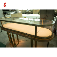 Vitrine de présentation de bijoux de luxe en verre blanc laiteux incurvé avec éclairage LED pour mobilier de magasin de détail haut de gamme