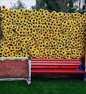 Pared floral artificial en tonos cálidos con flores amarillas y hojas verdes para decoración de pared en múltiples escenarios - Product Image 6