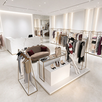 Portant à vêtements pour boutique, structure tubulaire dorée, table de présentation en marbre avec plateau en verre, rail de suspension, CE ETL, vente en gros et au détail
