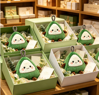 Peluche Zongzi en forme de ravioli de riz, enveloppée d'un tissu en velours côtelé vert triangulaire, avec visage souriant et membres marron, à suspendre