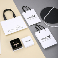 Ensemble sac en papier blanc A1 et boîte à bijoux avec poignées noires, base blanche, intérieur foncé, étui carré et présentoir de vente au détail