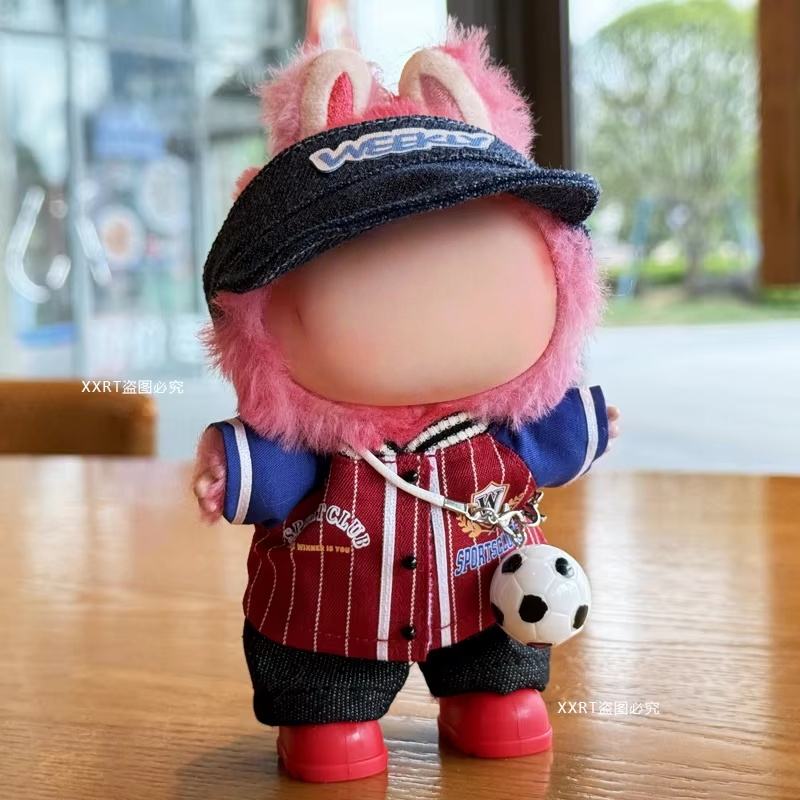 Haut rayé rouge, pantalon noir, casquette en denim, sac de football